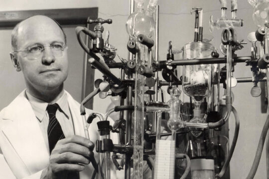 Harold Rusch conducting research with laboratory equipment.