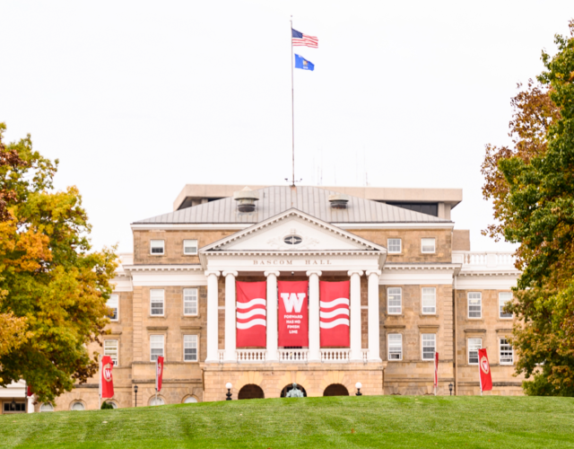 Bascom Hall adorned with red and white banners featuring an iconic W and phrase All Ways Forward.
