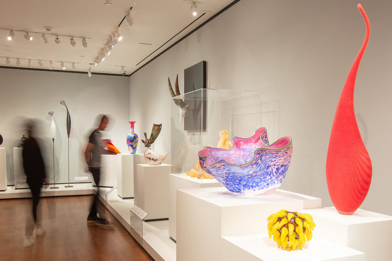 A photo of an exhibit featuring numerous brightly colored glass pieces.