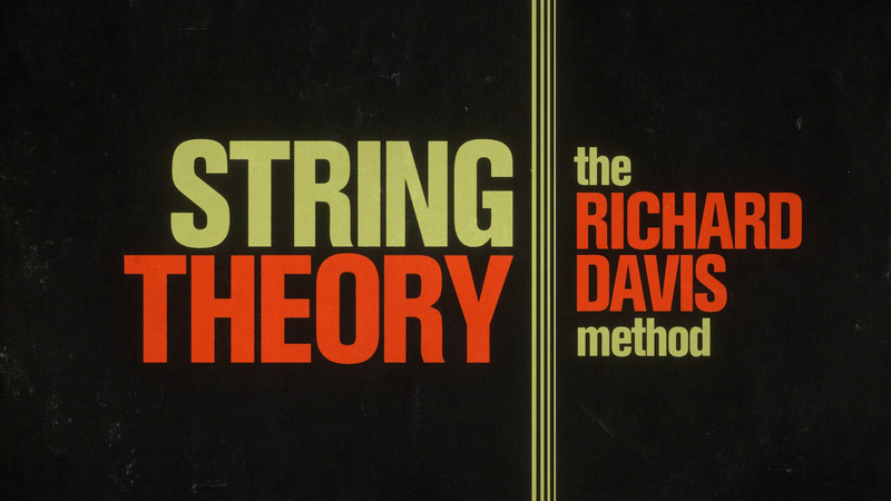 A photo of the String Theory title screen, with orange and yellow font plus a stripe down the center.