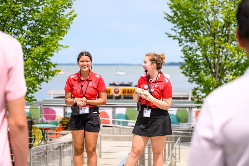 A photo of 2 CAVR students leading a tour in front of the water at Memorial Union.