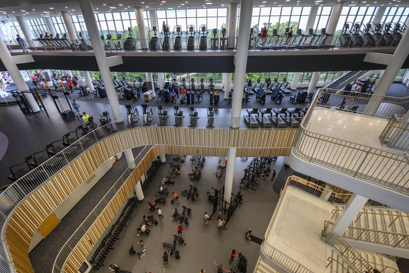 An aerial shot of the main space of the Bakke recreation center, with ellipticals, students, and other exercise equipment.
