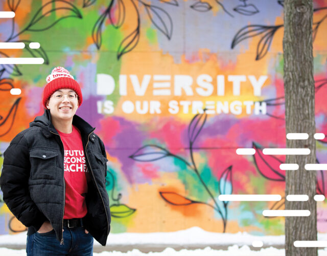 Person standing near colorful wall mural that reads, diversity is our strength.
