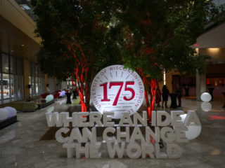 175 Gala - Where an Idea Can Change the World 3-D display stating, “Where an idea can change the world” in front of circular 175th anniversary logo positioned between uplight indoor trees.