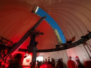 175 Open House - Washburn Observatory Observatory telescope peering through dome-slit during evening stargazing event.